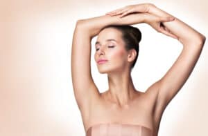 A woman showing her underarms after undergoing laser hair removal